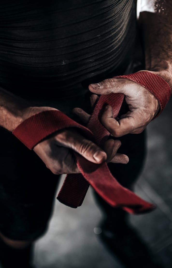 Man putting on straps for weight training