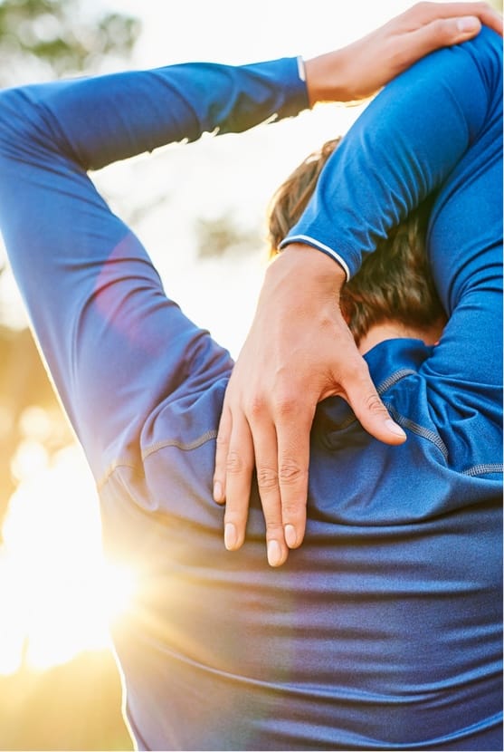 Man stretching his shoulder outside