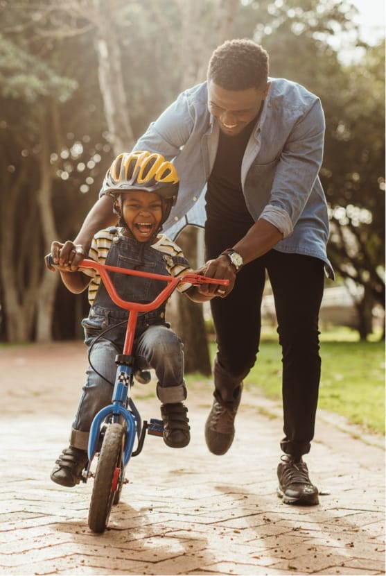 Father teaching son how to ride a bike