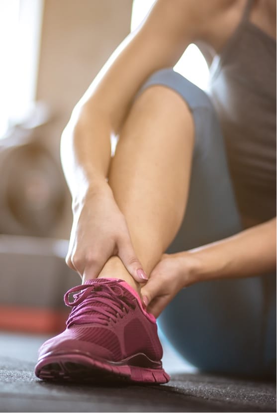 Close up of woman holding ankle in discomfort