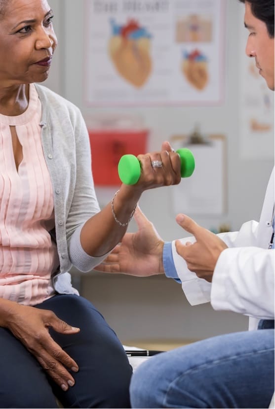 Woman lifting small weight while meeting with doctor