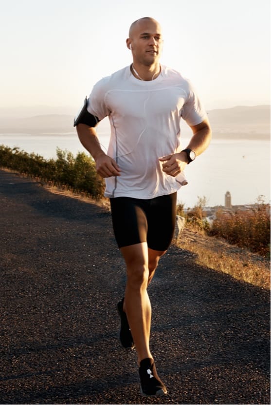 Man running outside with ocean in the background