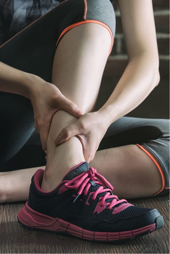 Close up of woman holding ankle in pain