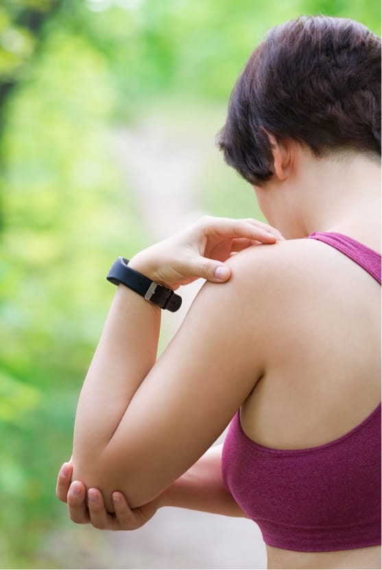 Close up of woman grabbing elbow outside after working out